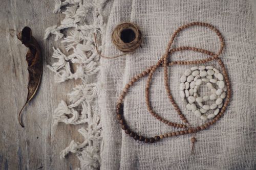 Free Top view of rustic beads and necklace on textured linen fabric. Stock Photo