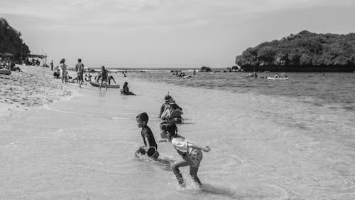 Free Grayscale Photograph of Children Playing at the Beach Stock Photo