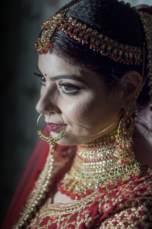 Free A captivating portrait of an Indian bride adorned in traditional jewelry and attire, showcasing cultural elegance. Stock Photo