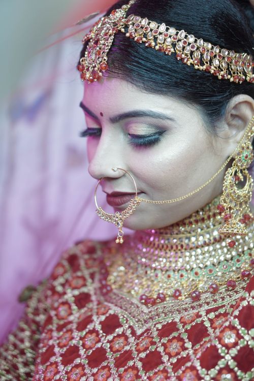 Free Close-up of a beautiful Indian bride adorned in traditional jewelry and attire, exuding elegance. Stock Photo