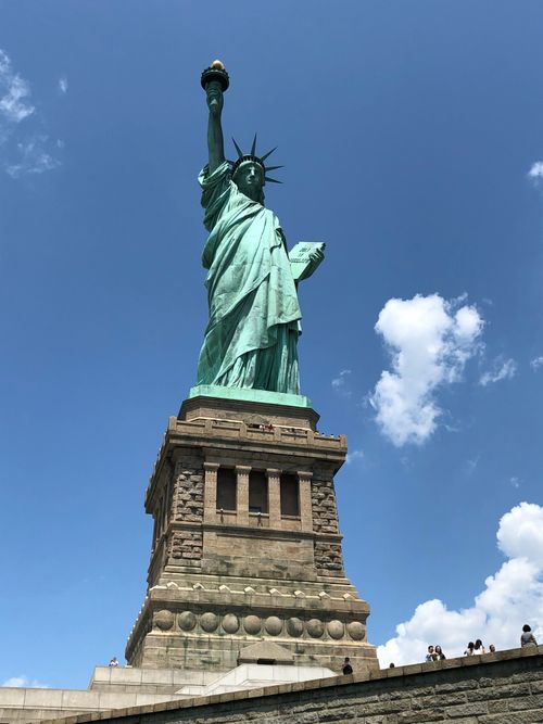 Free Iconic Statue of Liberty in New York City with a clear blue sky, a symbol of freedom and democracy. Stock Photo
