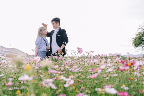 Free Man and Woman Sitting on Grass Field Stock Photo