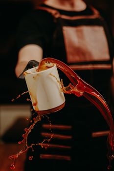 Artistic capture of coffee splashing from a ceramic cup held by a barista.