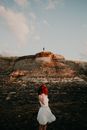 Redhead in Dress Looking at Person on Top of Mountain