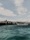 White and Black Ship on Sea Under White Clouds and Blue Sky