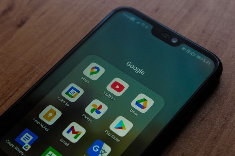 Close-up of a smartphone showing various Google apps on its screen