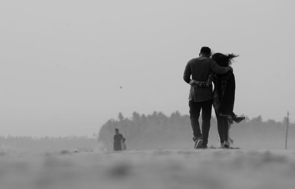 Free Grayscale Photography of Couple Walking on Ground Stock Photo