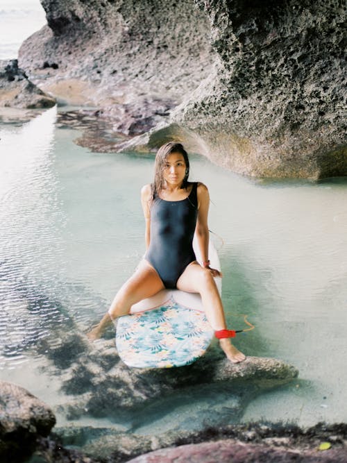 Photo of Woman Sitting on Surfboard