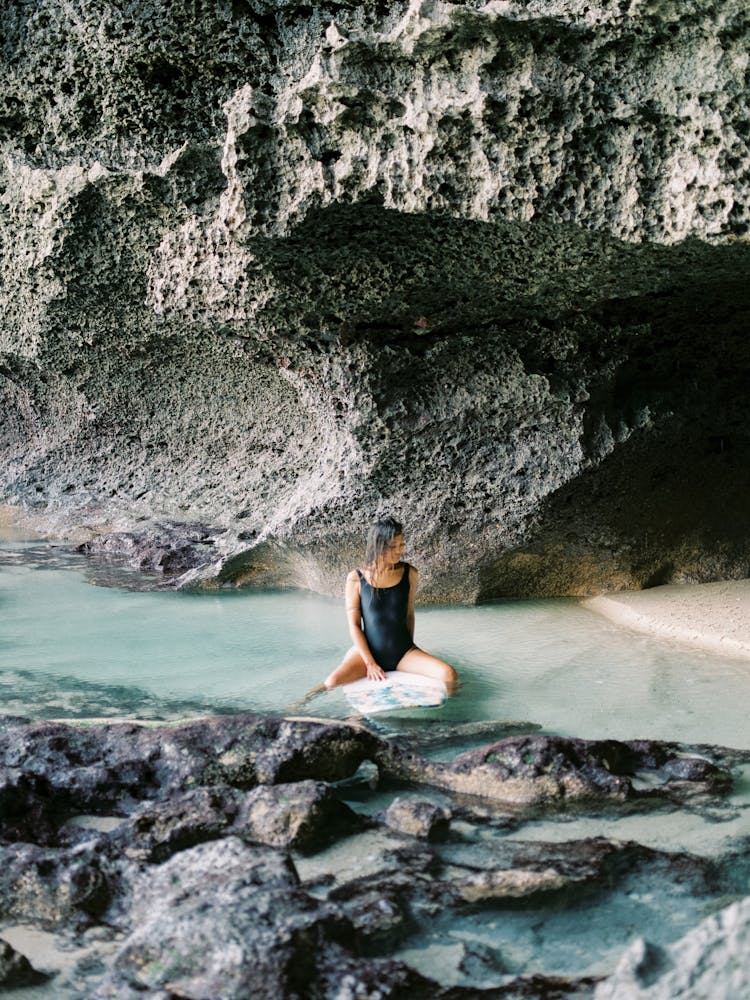 Woman Posing In Water Near Rocks