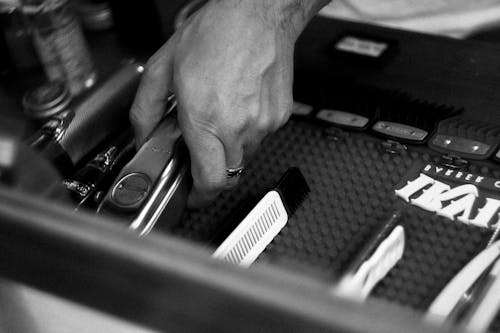 Grayscale of a Hand Putting the Barber Tool on a Tray