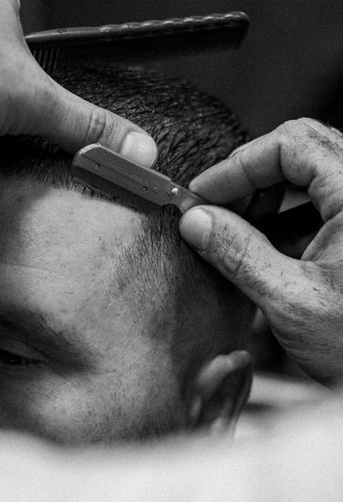 A Hand Shaving Client's Hair