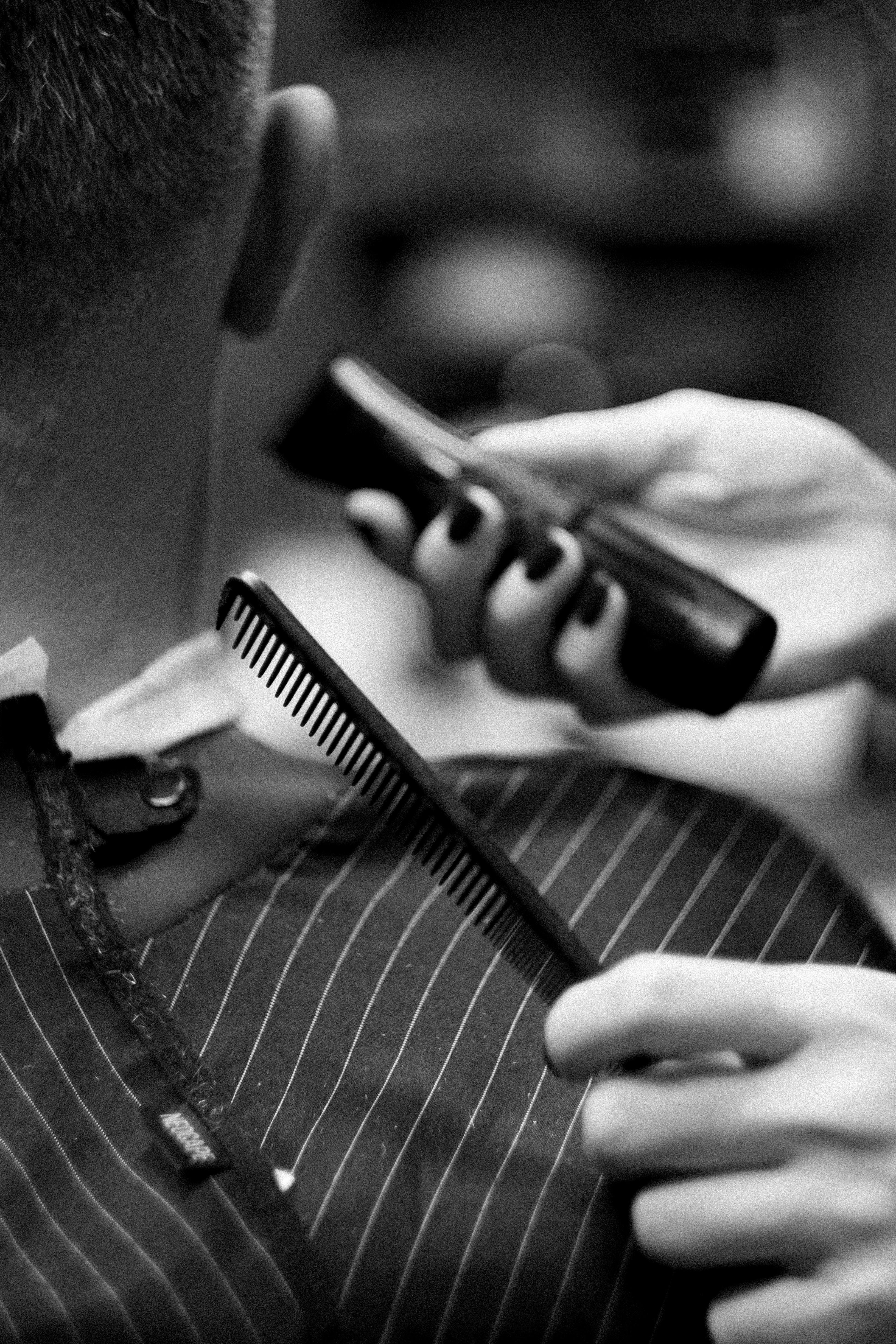A Person Holding Comb and Hair Clipper