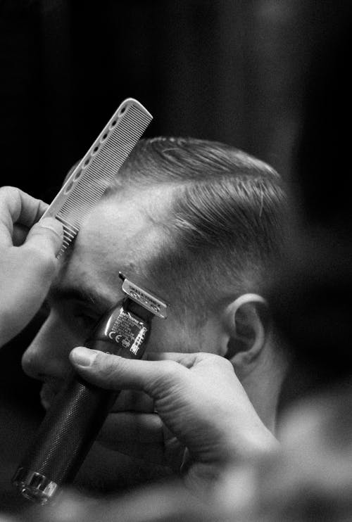 Grayscale Photo of Man Having Haircut 