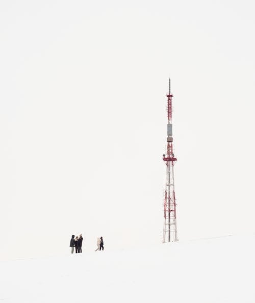 People Standing Near a Red and White Tower