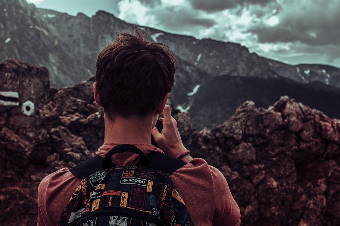 Man Taking Photos Of Mountains