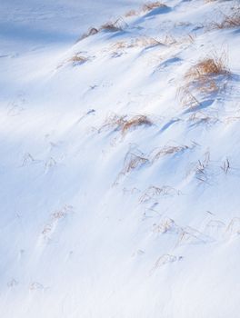 A peaceful winter scene of snow-covered grass on a soft gradient hill, evoking calm.