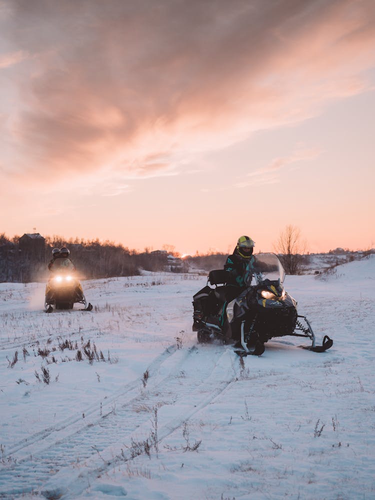 People Riding A Snowmobile Outdoors