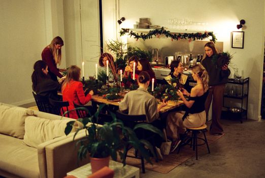 A group of women making wreaths in a festive home setting, perfect for Christmas inspiration.