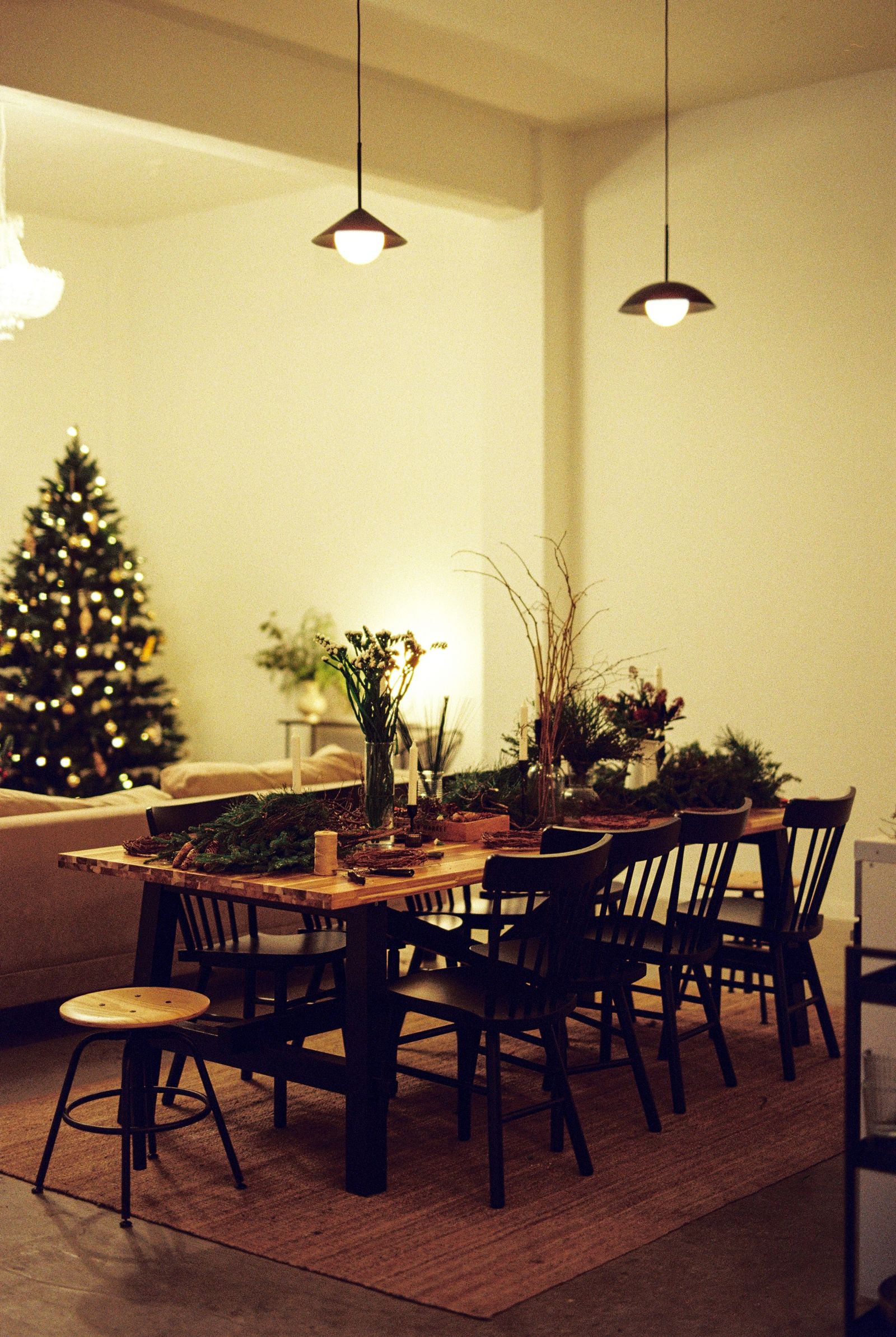 Dining table and chairs beside a Christmas tree in a lived-in living room.