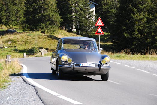 Classic Citroen DS car driving along a scenic road in Partenen, Austria.