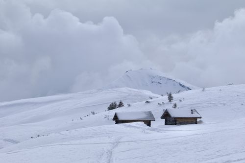 Free Peaceful winter scene with wooden huts in snowy mountains of Alta Badia, Italy. Stock Photo