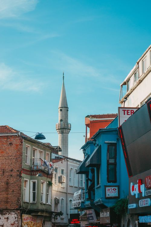 Free Historic street view showcasing colorful buildings and a mosque minaret under a clear sky. Stock Photo