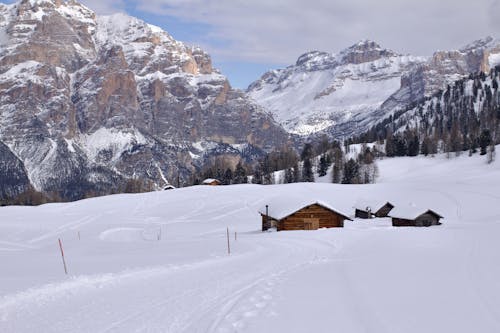 Wooden Huts in the Snow Covered Dolomite Mountains