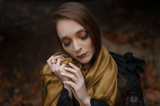 A thoughtful woman in a scarf embraces the tranquil vibes of autumn.