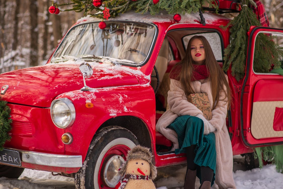 Woman in Red Car with Christmas Tree on top