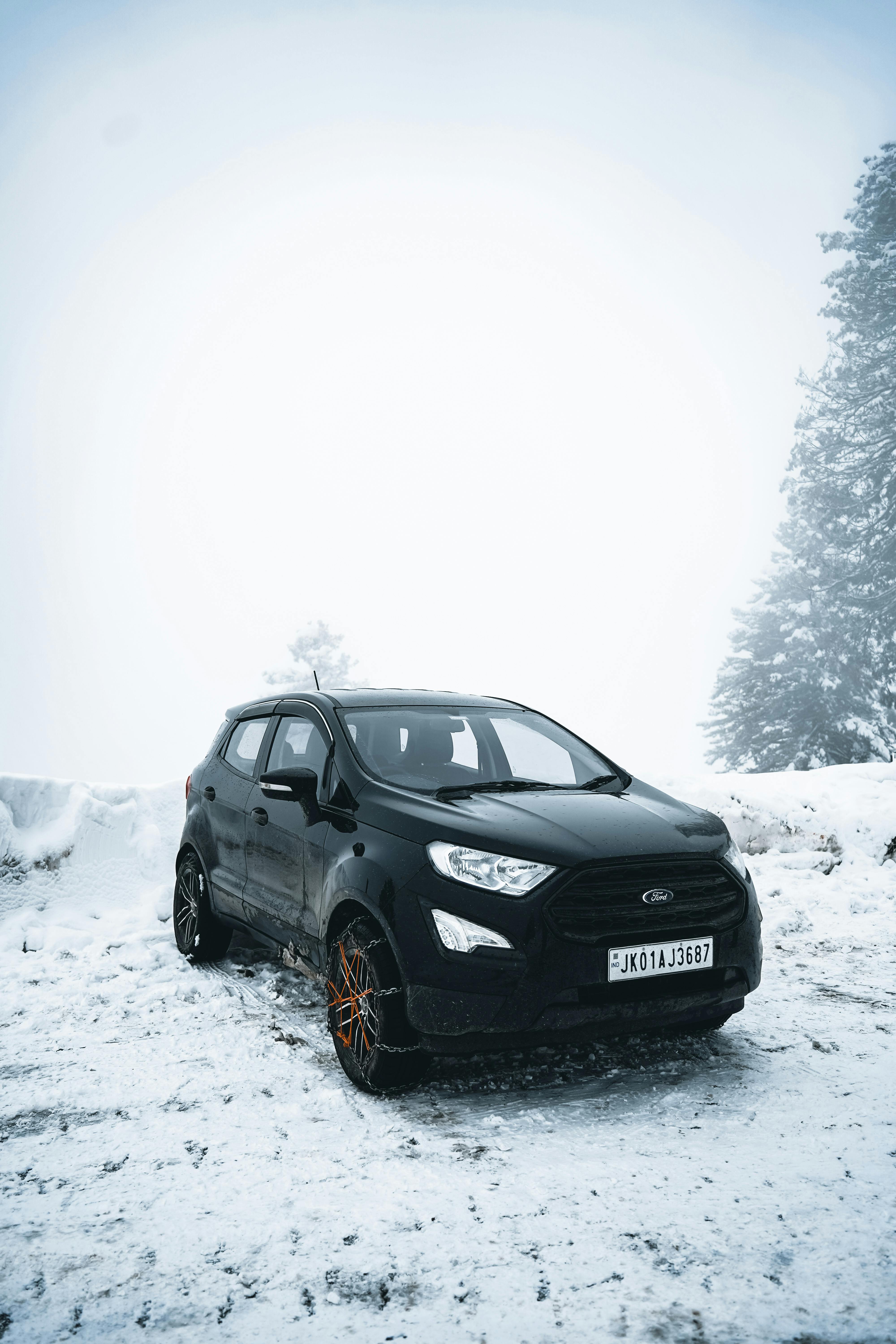 Prescription Goggle Inserts - Black SUV parked on a snowy mountain road with trees in the background, during a cold winter day.