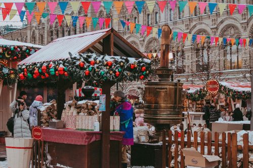 Free Lively market scene featuring colorful banderitas, festive stalls, and a bustling crowd in winter. Stock Photo