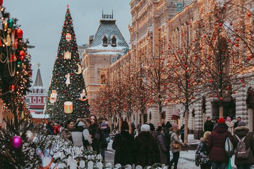 Free A bustling Christmas market with lights, decorations and a festive tree in an urban setting. Stock Photo
