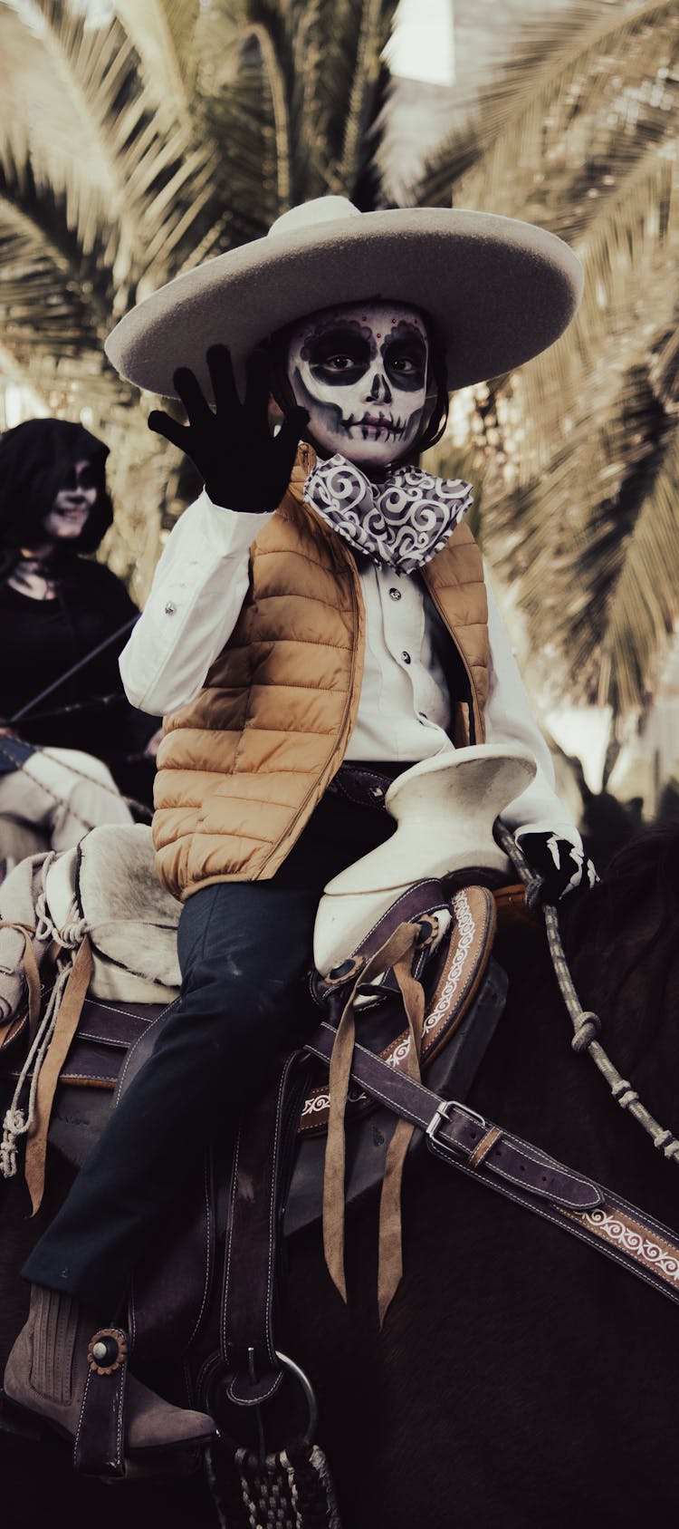 A Kid In Costume Riding A Horse During The Day Of The Dead Parade In Mexico