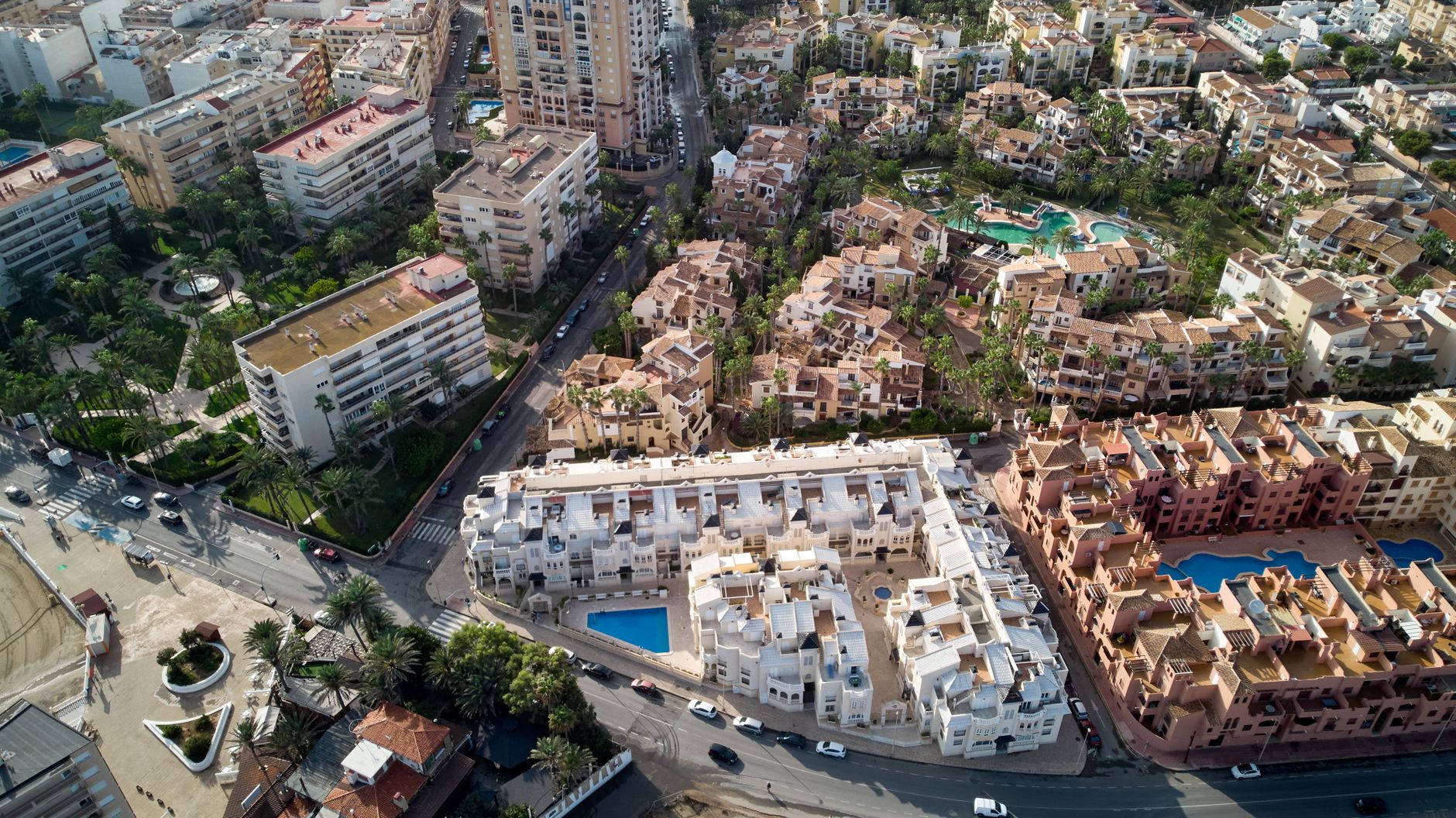 Gemeenschappelijk zwembad bij een Spaans wooncomplex met appartementen en gedeelde tuin.