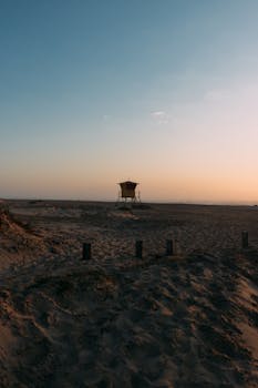 Peaceful morning view of lifeguard tower on Arroio do Silva beach under soft sunrise light.