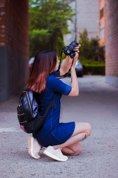 女摄影师跪着用相机捕捉城市场景