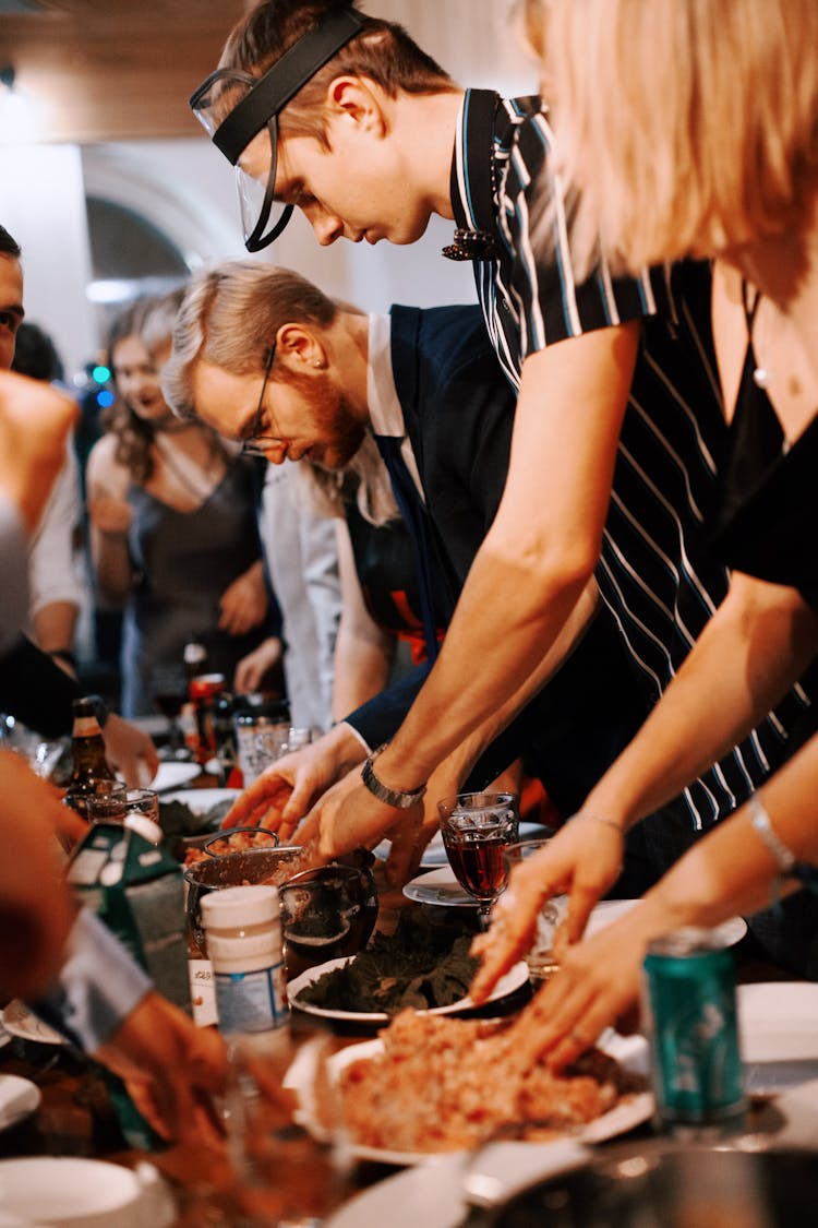 People Taking Food From Table