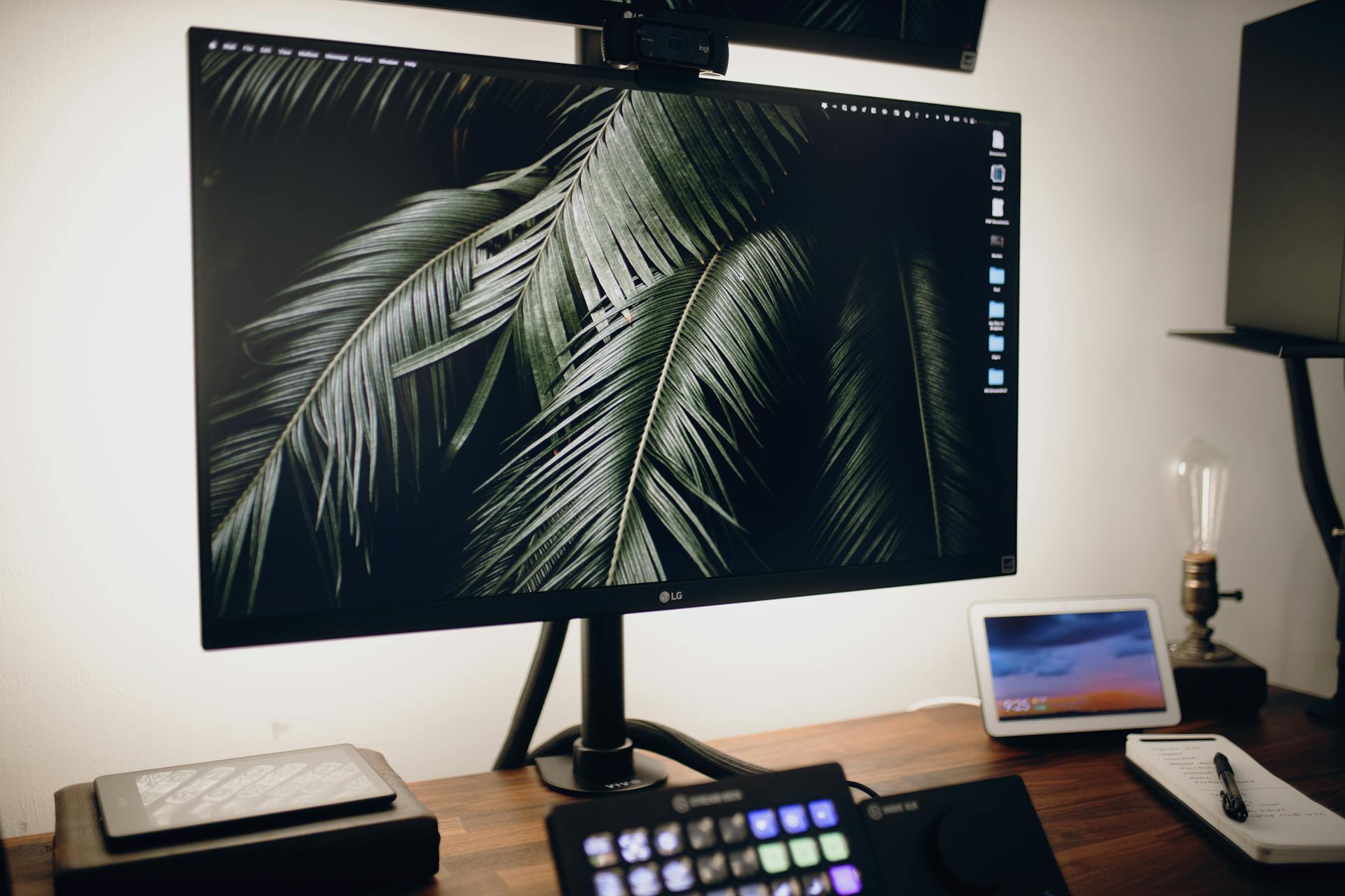 A modern desktop setup featuring a large monitor, tablet, and tech accessories for a stylish workspace.
