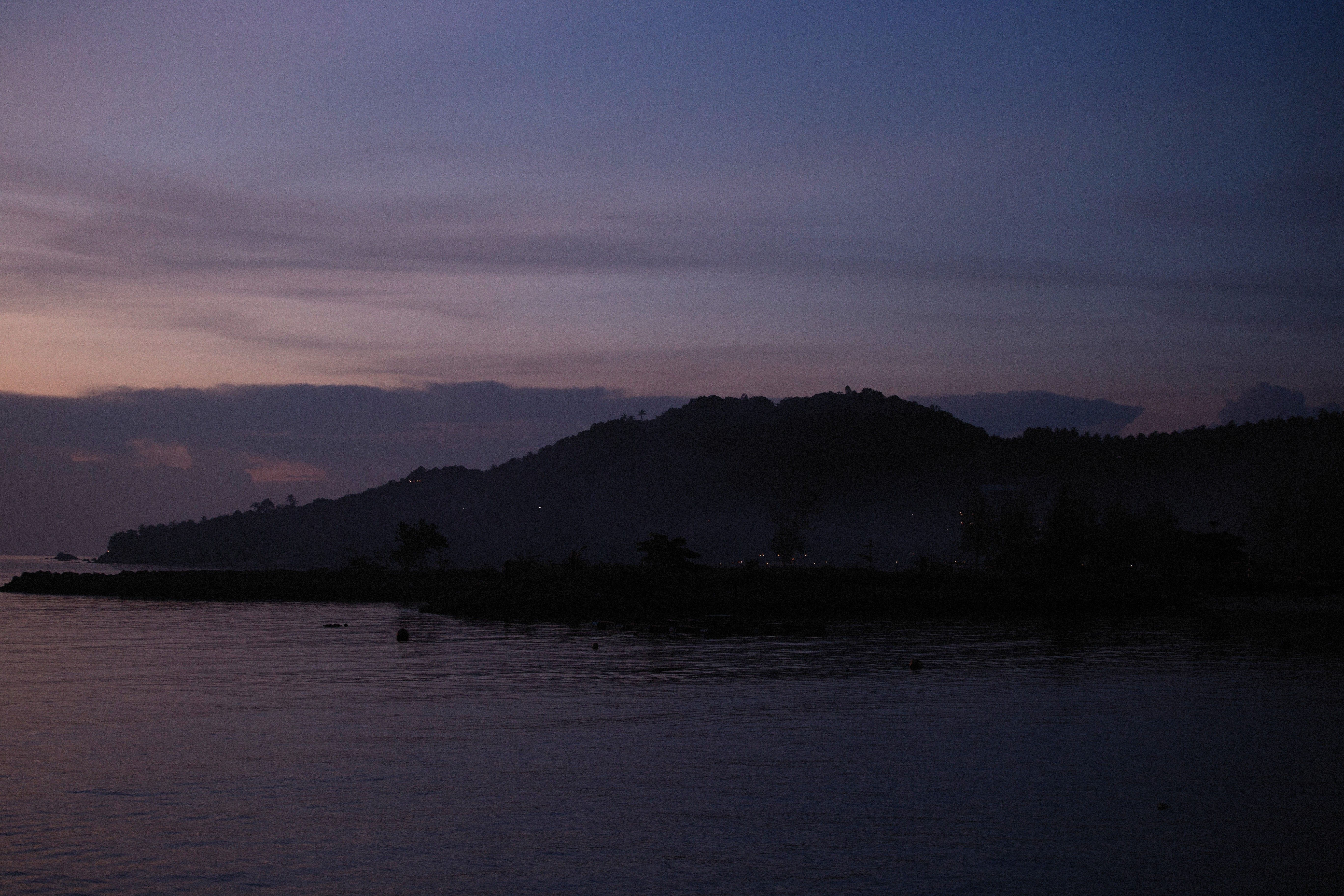 Silhouette of Mountain Near Body of Water during Sunset · Free Stock Photo