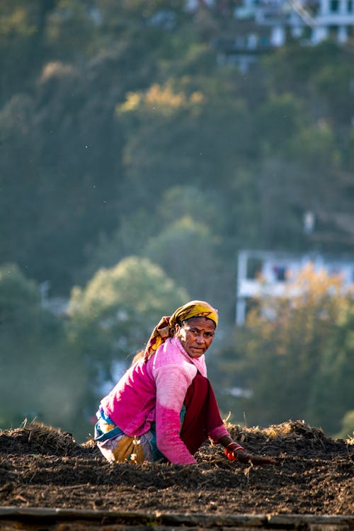 Woman in Pink Long Sleeve Shirt on Brown Soil