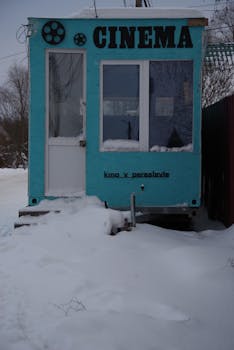 A quaint blue cinema with snowy surroundings in Pereslavl-Zalessky during winter.