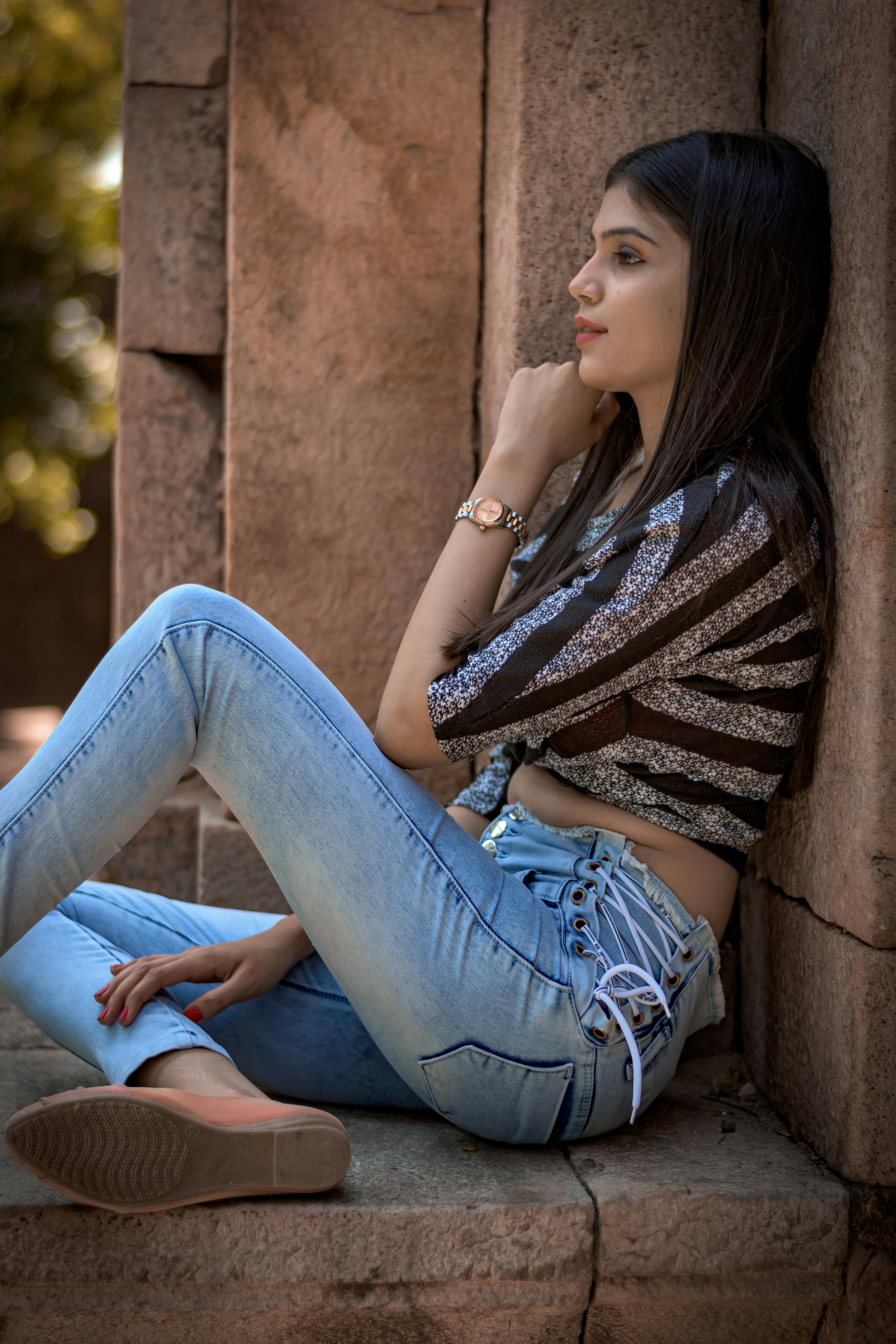pretty woman in jeans posing on brick wall background Stock Photo - Alamy