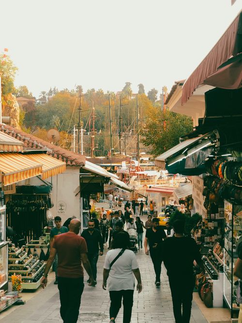 Free Vibrant street market scene with people walking along shops during the day. Stock Photo