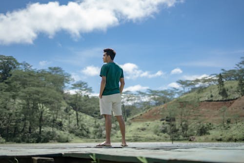 A Man Wearing a Green Shirt and Shorts