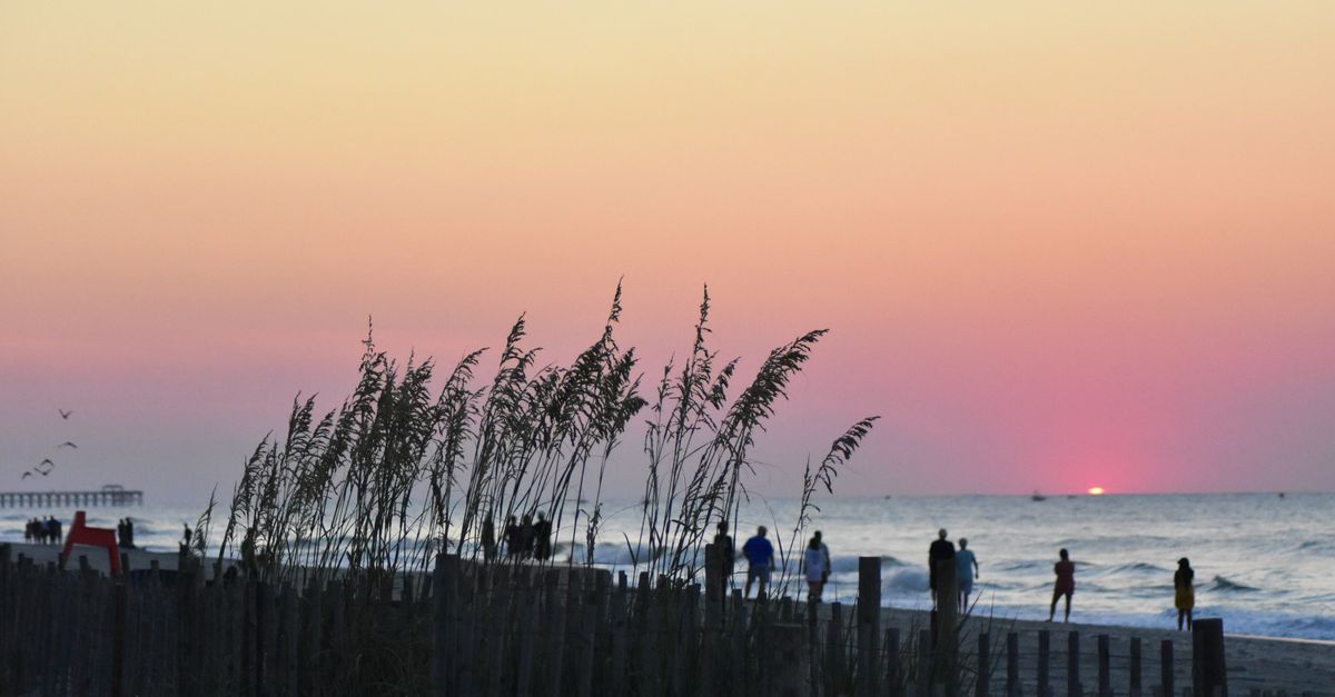 Beautiful sunset view at Myrtle Beach with silhouettes and vibrant sky colors.
