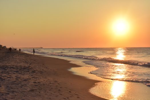 A tranquil sunrise view over Myrtle Beach with gentle waves and a golden horizon.