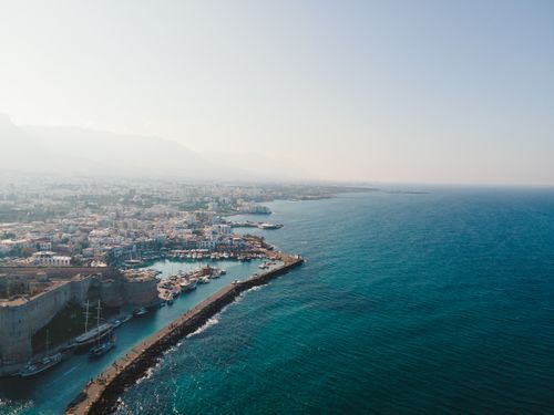 Free Breathtaking aerial view of a coastal city with vast blue ocean under clear skies. Stock Photo