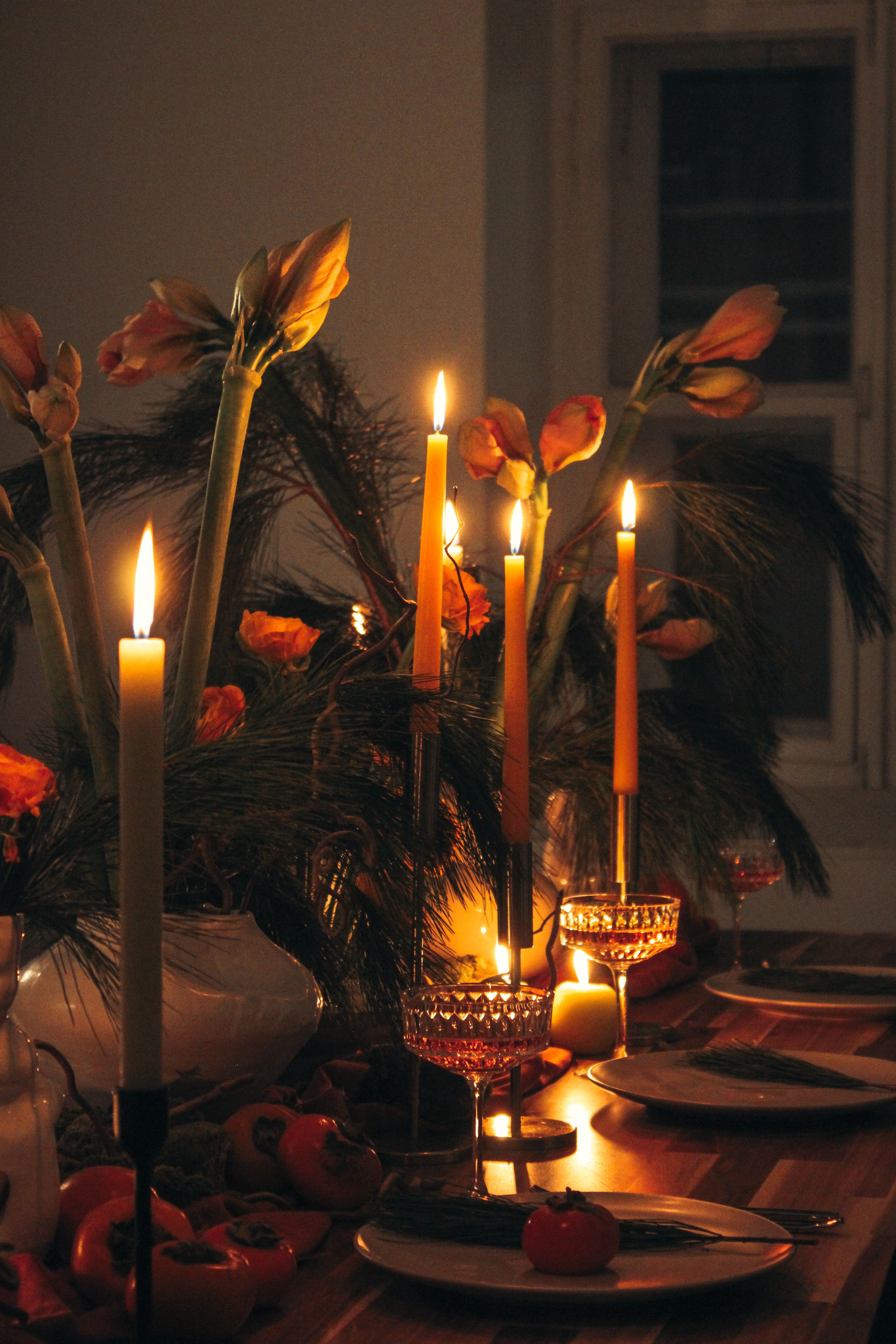 Milestone birthday decor ideas with tall candles and flowers on a wooden celebration table