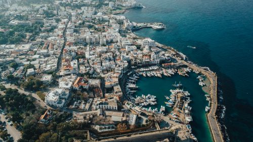 Free A stunning aerial shot of a coastal city with a bustling harbor and marina, showcasing urban life by the sea. Stock Photo