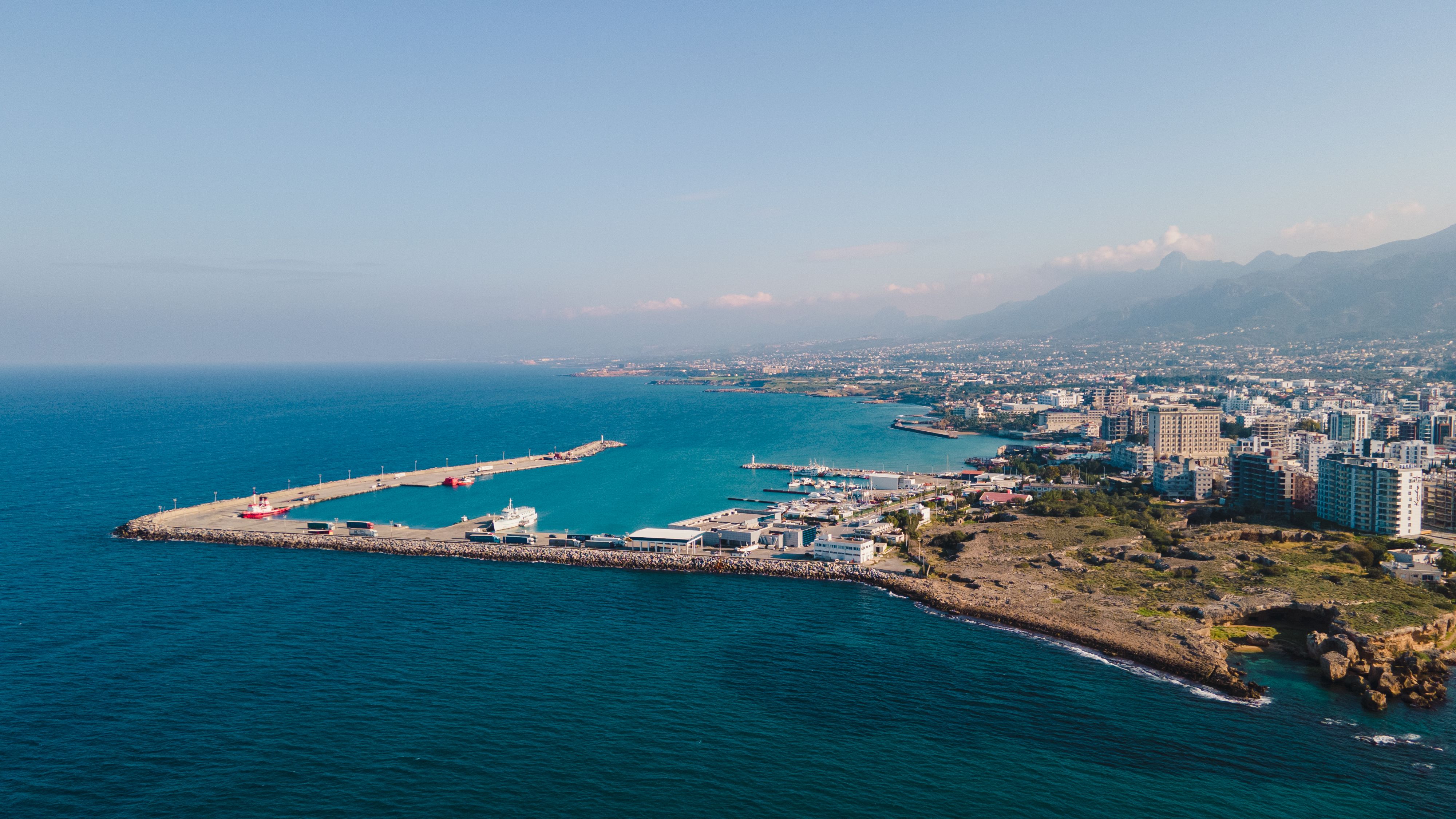 Aerial view of a coastal city with a vibrant harbor and a clear blue sky. - Photo by Tolga Aslantürk on Pexels